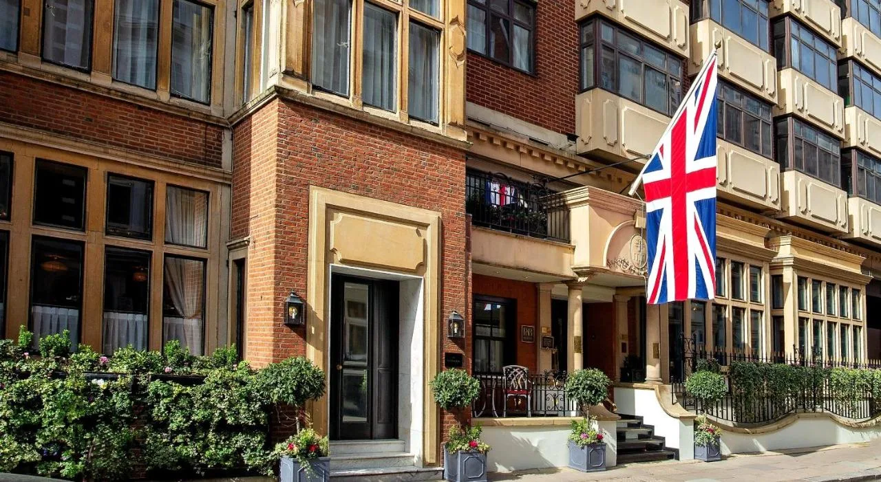 a British flag flying in front of a building at The Capital Hotel, Apartments & Townhouse in Knightsbridge, London