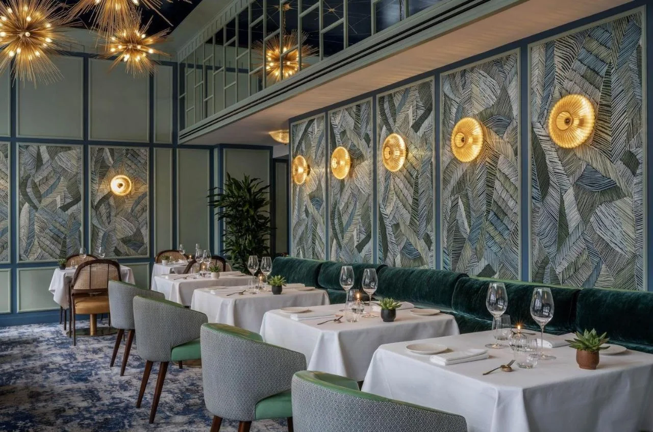 a restaurant with white tables and chairs at The Capital Hotel, Apartments & Townhouse in London