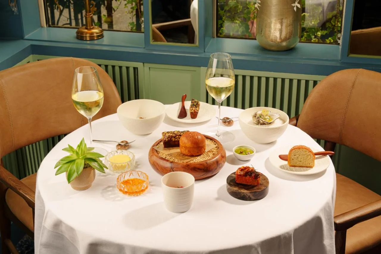 a white table with food and glasses of wine at The Capital Hotel, Apartments & Townhouse in London