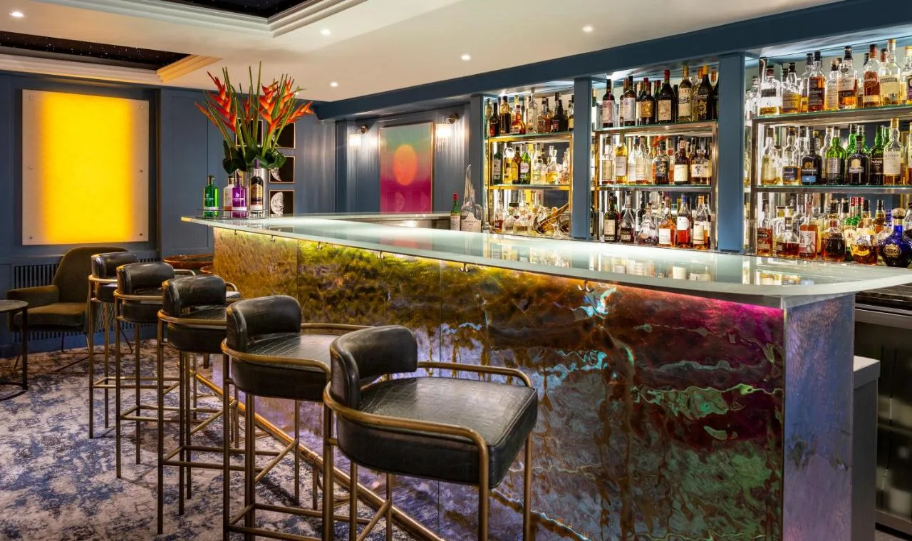 a bar in a hotel with bar stools at The Capital Hotel, Apartments & Townhouse in London