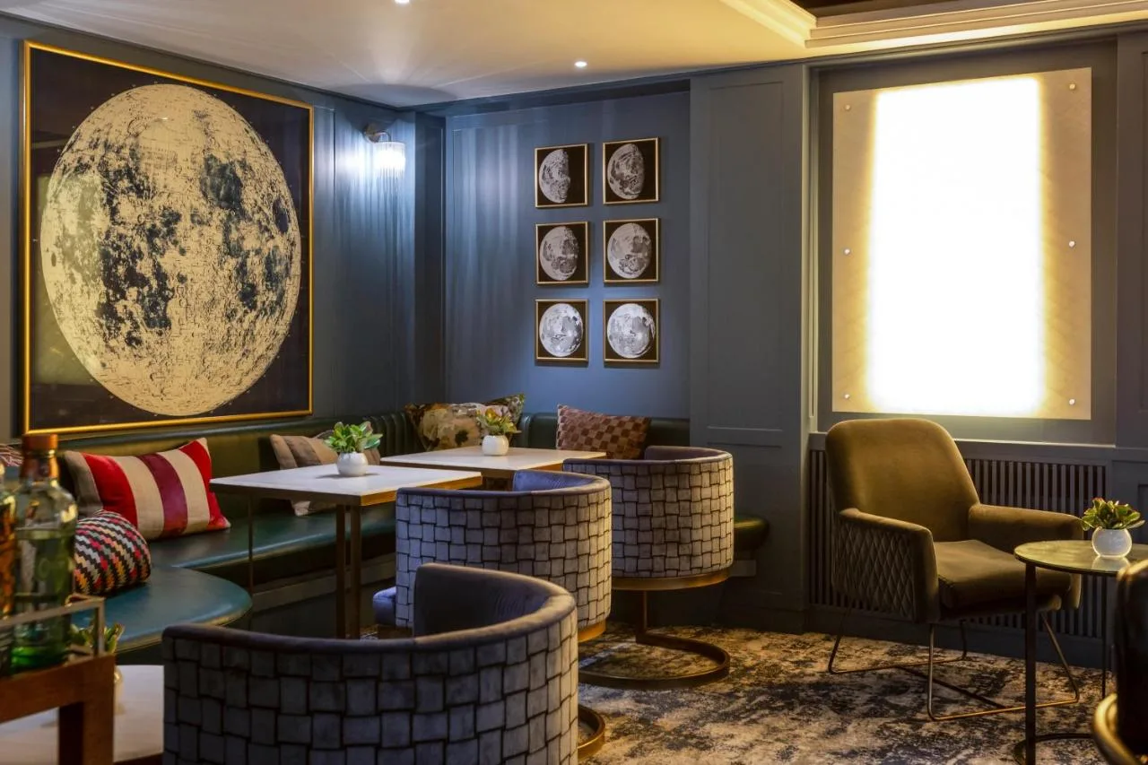 a restaurant with tables and chairs and a window at The Capital Hotel, Apartments & Townhouse in London
